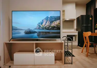 Modern living room with large TV and stylish kitchen area