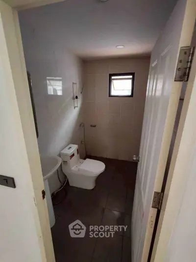 Compact bathroom with modern fixtures and small window for natural light.