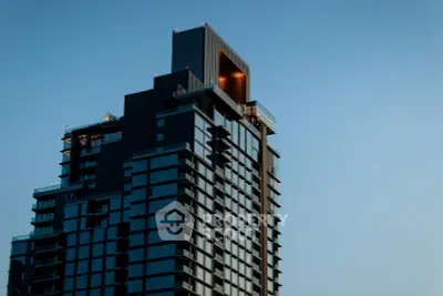 Modern high-rise building with sleek architecture against a clear blue sky.