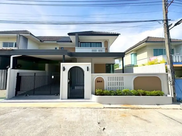 Modern two-story house with gated entrance and driveway in a suburban neighborhood.