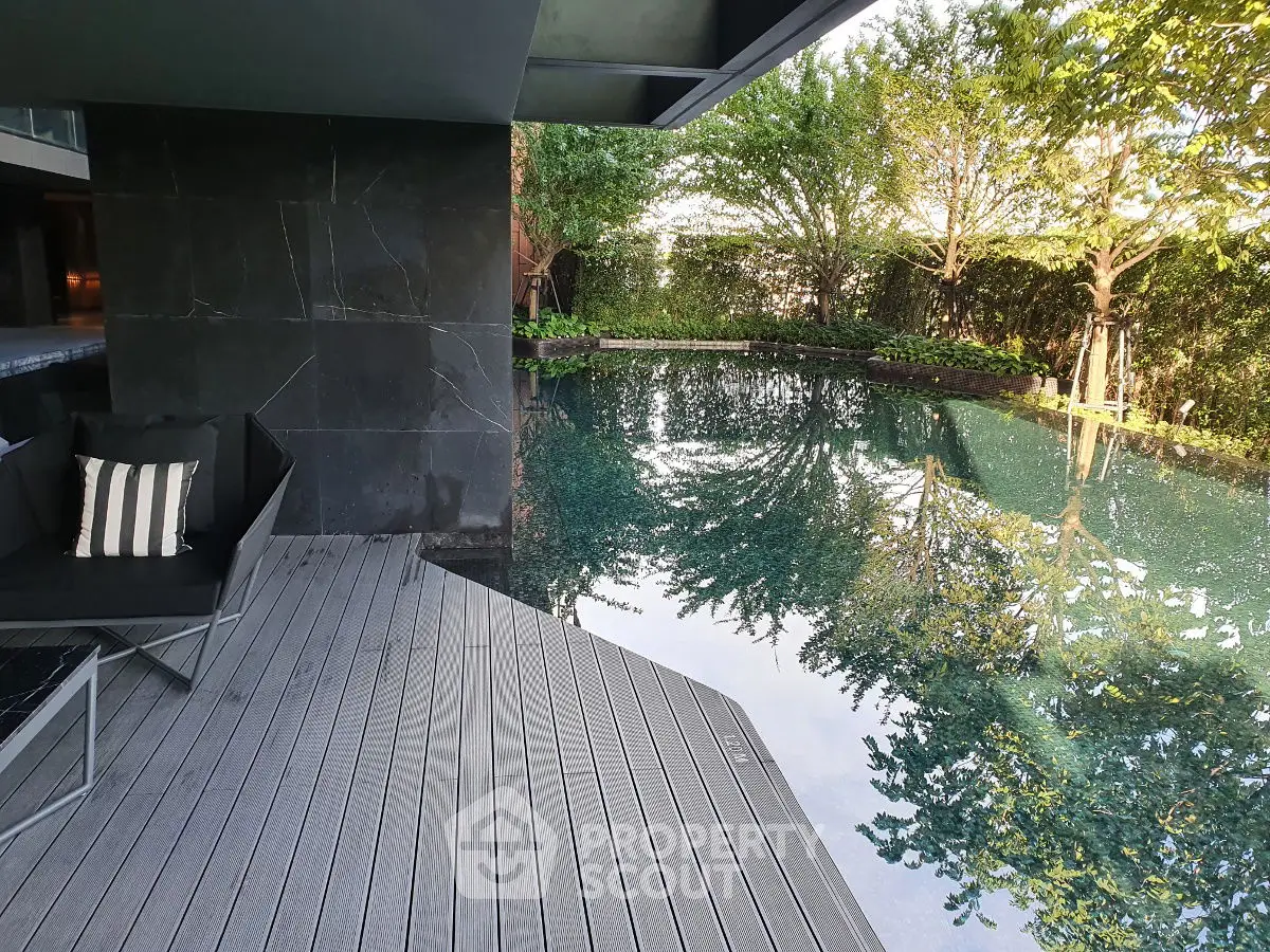 Luxurious poolside area with modern design and lush greenery, perfect for relaxation and leisure.