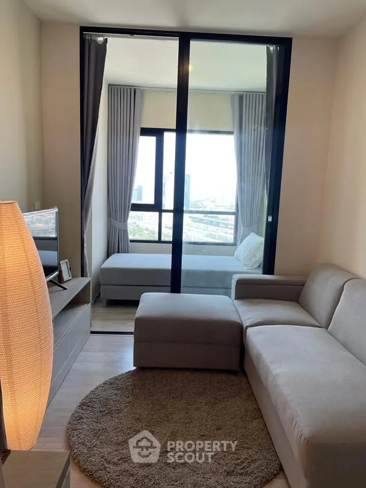 Modern living room with cozy sofa and city view from balcony