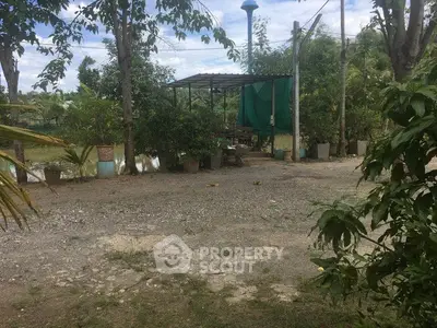 Charming rural property with lush greenery and outdoor seating area, perfect for nature lovers.