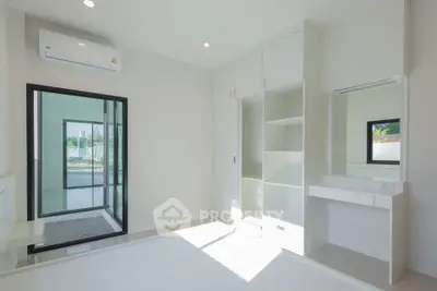 Bright modern bedroom with built-in wardrobe and air conditioning, featuring sleek minimalist design.