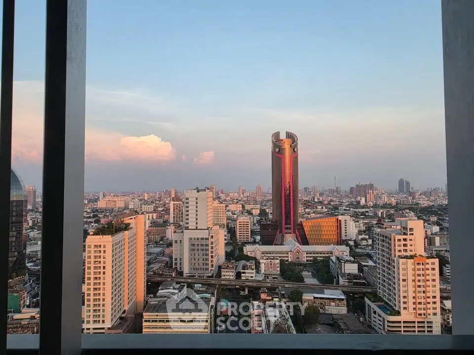 Stunning cityscape view from a high-rise building balcony at sunset, showcasing urban skyline.