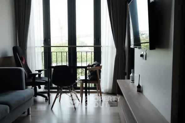 Modern living room with large windows and stylish furniture, offering a cozy and inviting atmosphere.