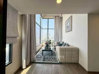 Spacious modern living room with floor-to-ceiling windows and elegant decor