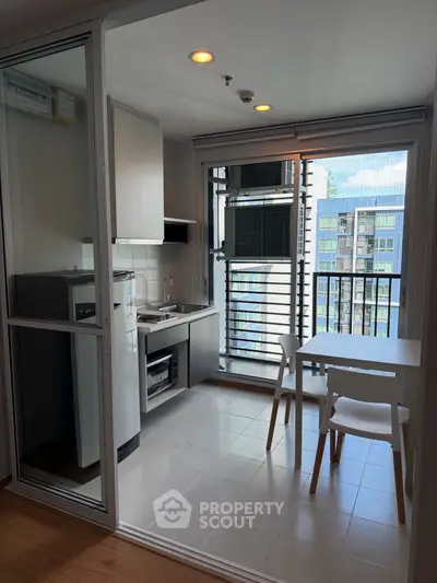 Modern kitchen with open layout and balcony view in urban apartment