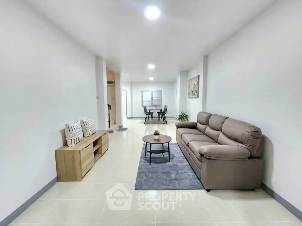 Spacious modern living room with cozy sofa and stylish decor in a bright apartment.