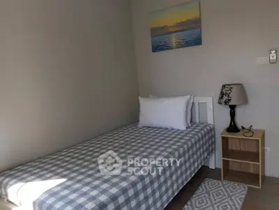 Cozy bedroom with single bed, nightstand, and serene wall art in a minimalist design.