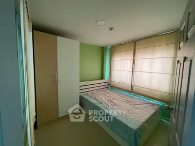 Cozy bedroom with natural light and modern wardrobe in a stylish apartment.