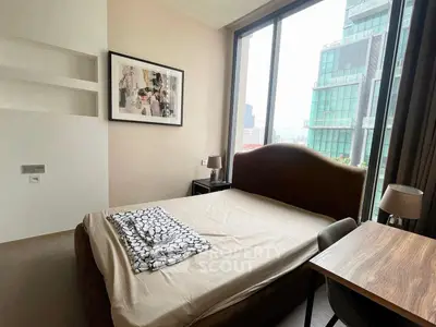 Modern bedroom with large window and stylish decor in urban apartment