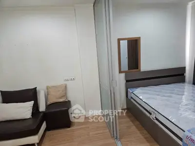 Modern bedroom with sliding glass partition and cozy seating area, perfect for urban living.