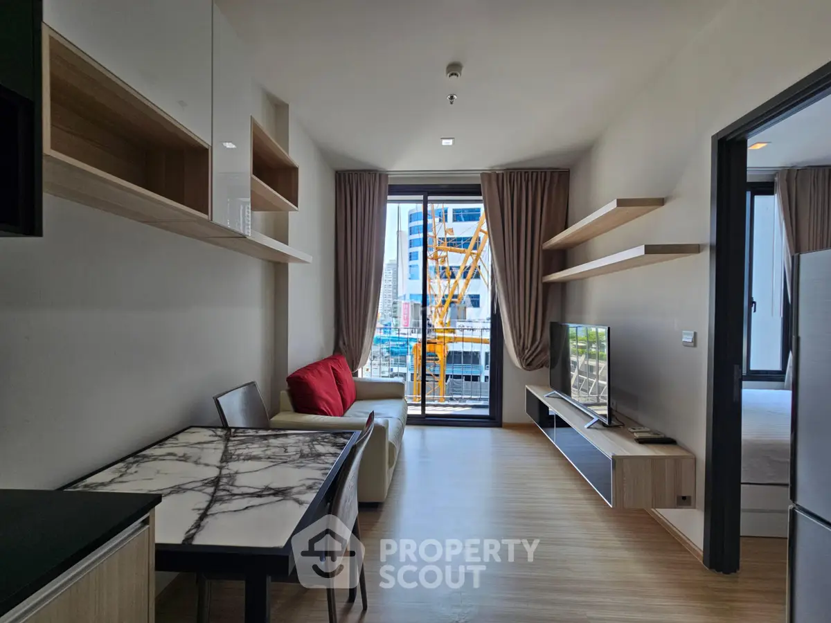 Modern living room with open layout, stylish furniture, and city view from balcony.