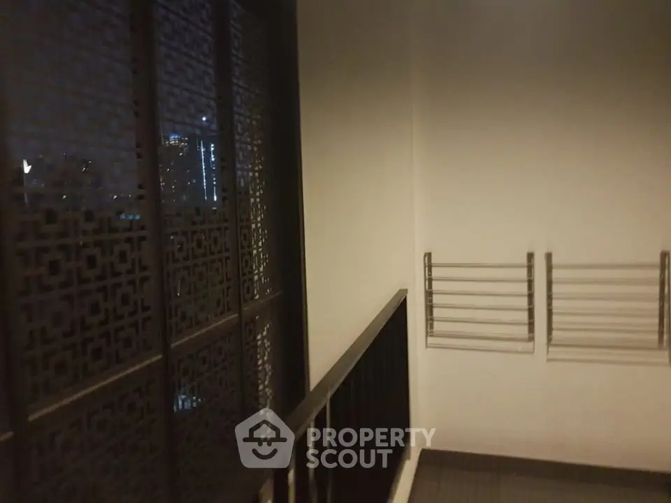 Modern balcony with city view and sleek railing design at night.