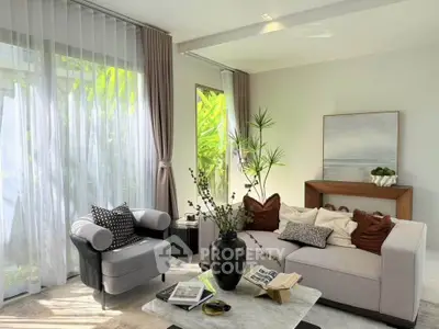Elegant living room with modern decor, large windows, and lush greenery view.