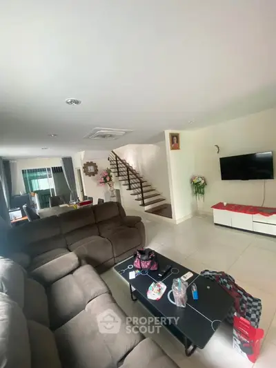 Spacious living room with modern decor and staircase in a cozy home.