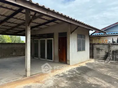 Spacious outdoor area with covered patio and concrete flooring, ideal for versatile use.