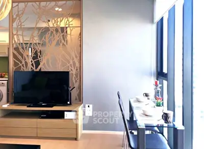 Modern living room with TV, dining area, and large windows offering natural light.
