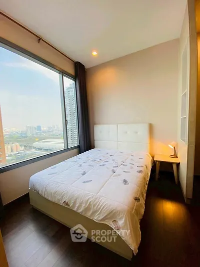 Cozy bedroom with city view, featuring a comfortable bed and modern decor.