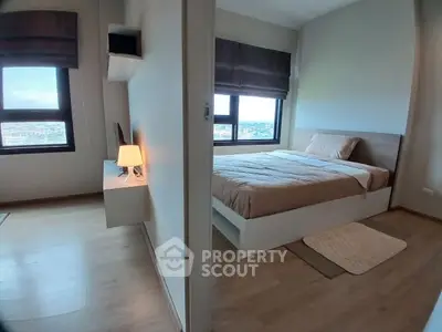 Modern bedroom with large windows and cozy decor in a high-rise apartment.