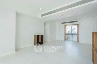 Spacious modern living room with large windows and sleek flooring in a contemporary apartment.