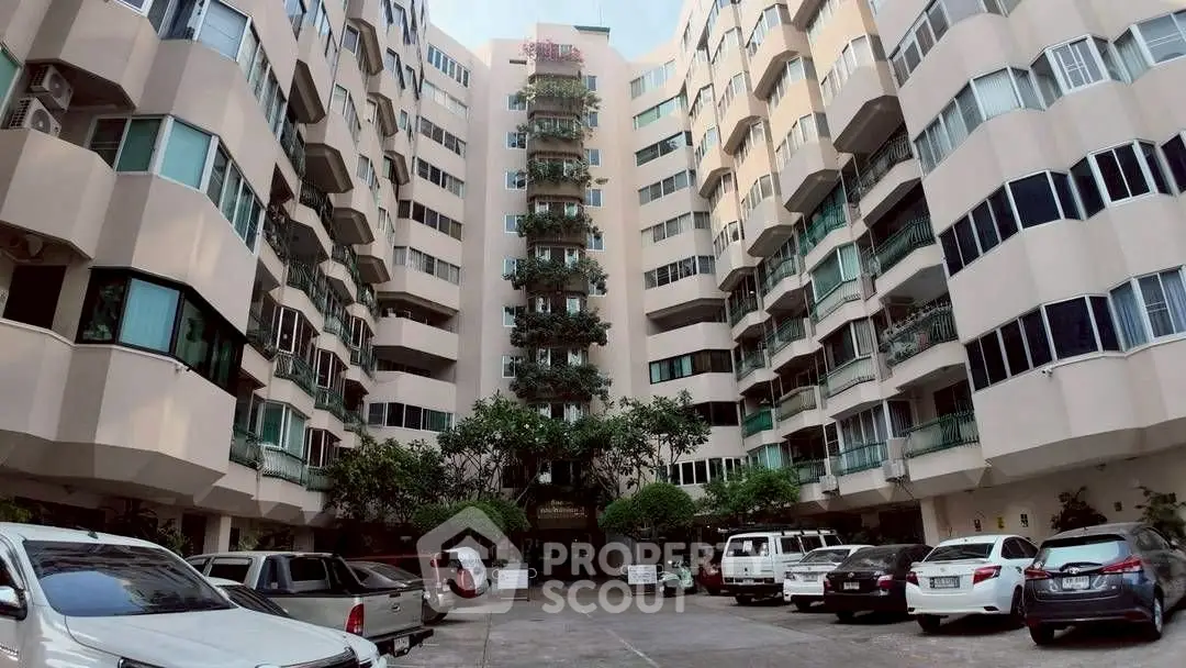 Spacious residential building with ample parking and lush greenery, perfect for urban living.