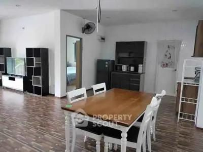 Spacious open-plan living and dining area with modern furnishings and wooden flooring.