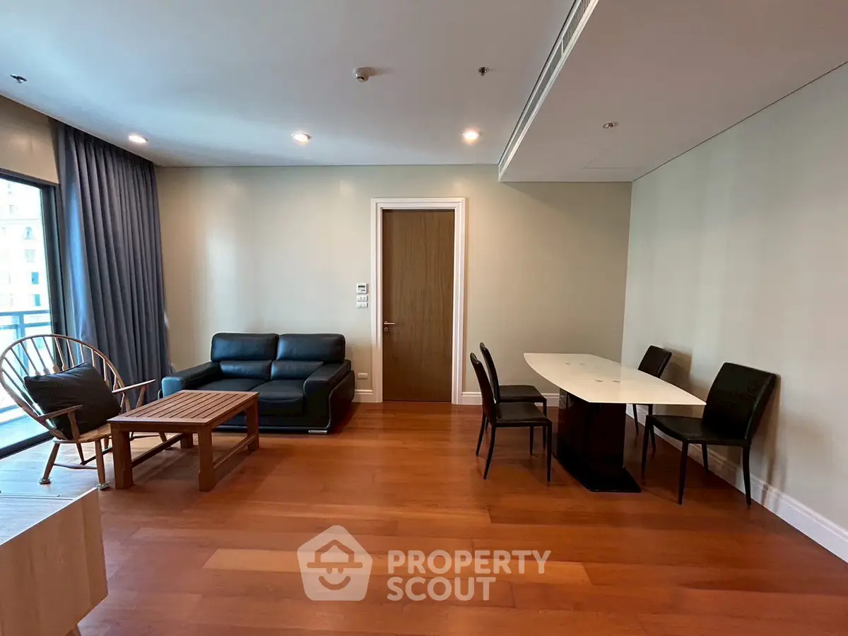 Spacious living room with modern furniture and wooden flooring in a stylish apartment.