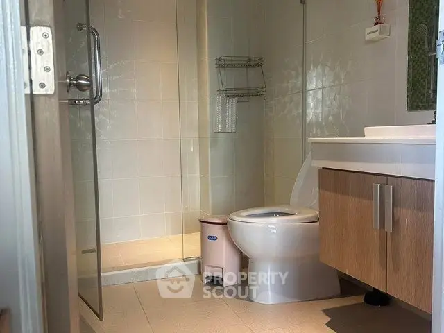 Modern bathroom with glass shower and sleek vanity in a contemporary home.