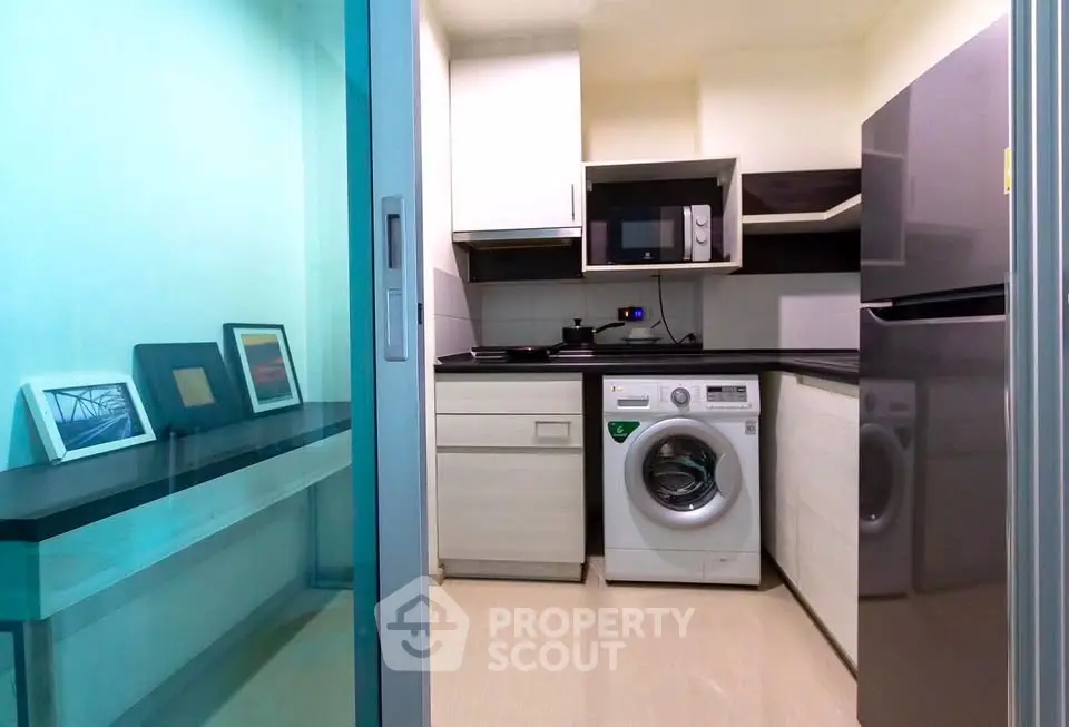 Modern compact kitchen with washing machine and sleek appliances