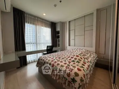 Spacious bedroom with modern decor and large window offering city views.