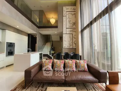 Luxurious open-plan living space with high ceilings, modern kitchen, and expansive windows offering ample natural light.