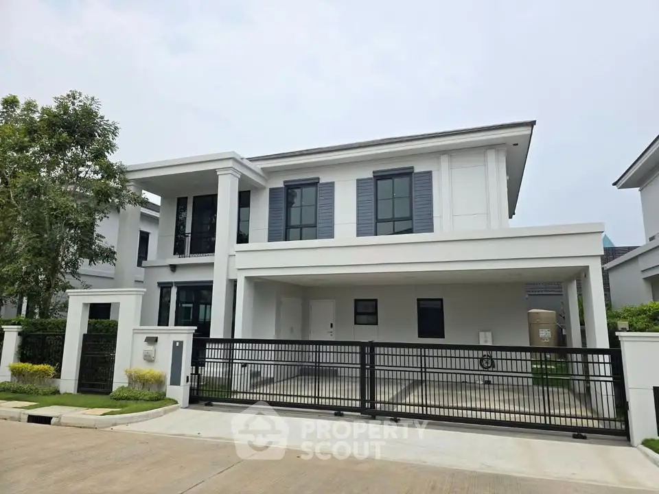 Modern two-story house with sleek design and spacious driveway in a serene neighborhood.