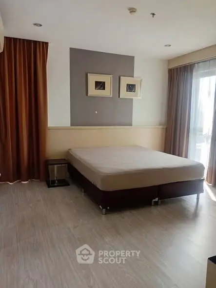 Spacious bedroom with modern decor and large windows for natural light.