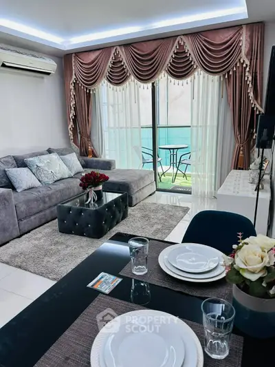 Luxurious living room with elegant drapes, plush sofa, and balcony view in modern apartment.
