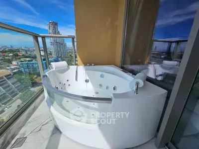 Luxurious balcony with jacuzzi offering stunning city views in high-rise apartment.