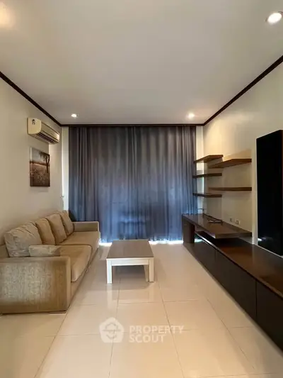Spacious living room with modern furniture and large window for natural light.