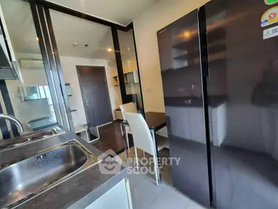 Modern kitchen with sleek appliances and dining area in contemporary apartment