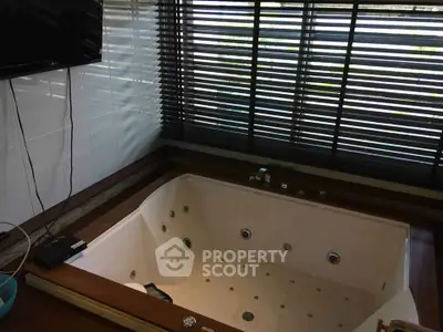 Luxurious bathroom with jacuzzi and large windows for natural light.