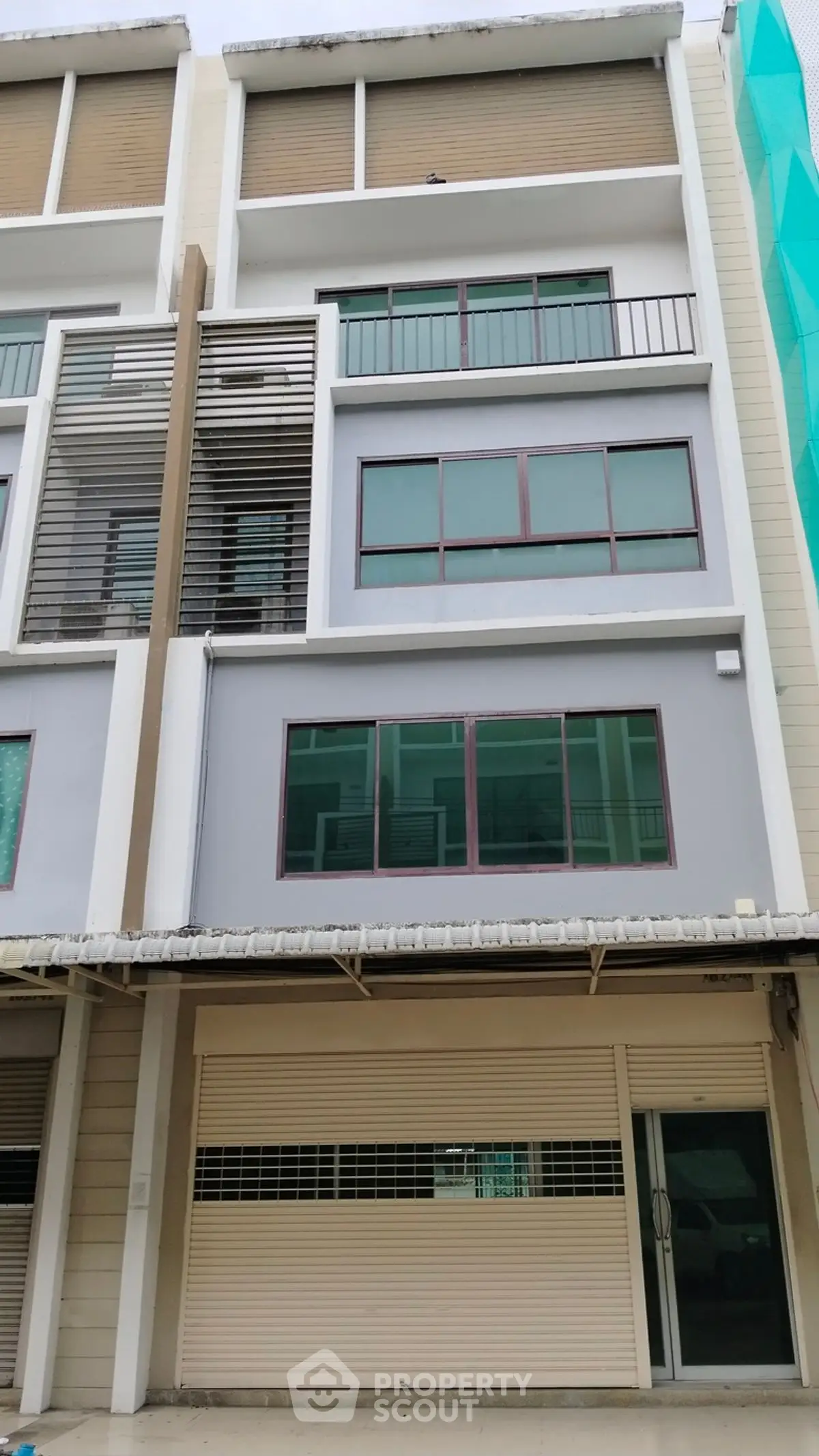 Modern multi-story building with large windows and garage door, ideal for commercial or residential use.