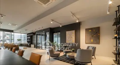 Spacious modern living room with stylish furniture and large windows offering natural light.