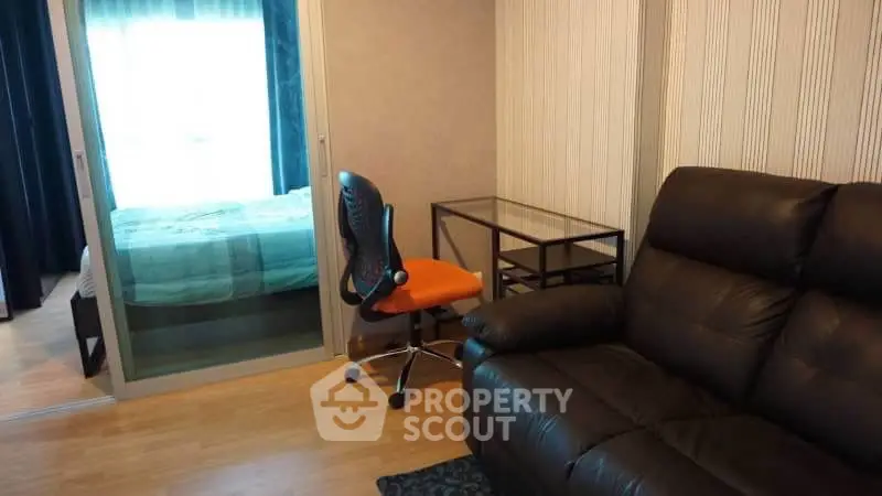 Cozy living room with leather sofa and study area in modern apartment