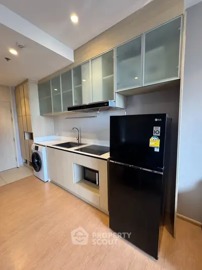 Modern kitchen with sleek appliances and ample storage in a stylish apartment.