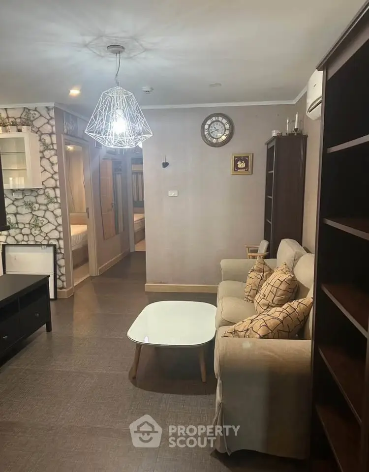 Cozy living room with modern lighting and comfortable seating in a stylish apartment.