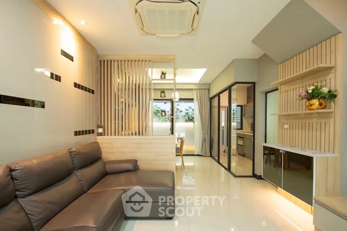 Modern living room with sleek design and open layout, featuring a cozy leather sofa and stylish decor.