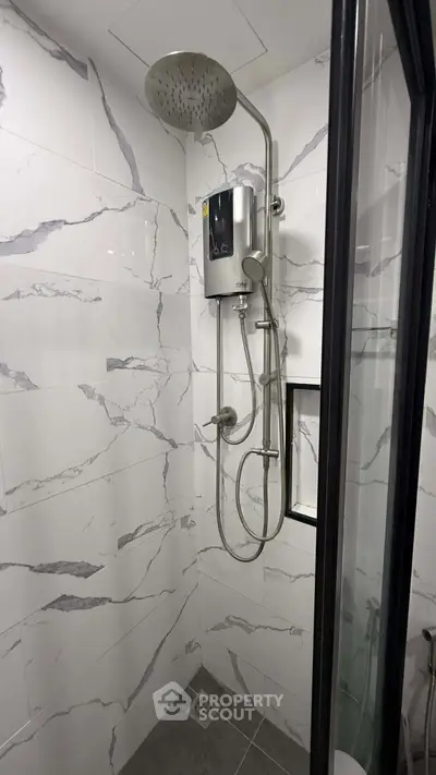 Modern bathroom with sleek shower fixtures and marble-style tiles