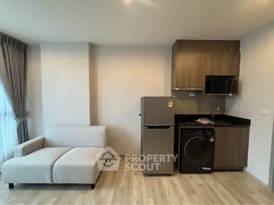 Modern studio apartment with compact kitchen and cozy living area, featuring sleek appliances and stylish decor.