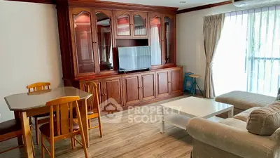 Spacious living room with elegant wooden cabinet and cozy seating area.
