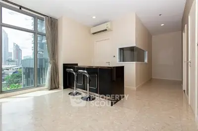 Modern apartment interior with city view and sleek kitchen island.